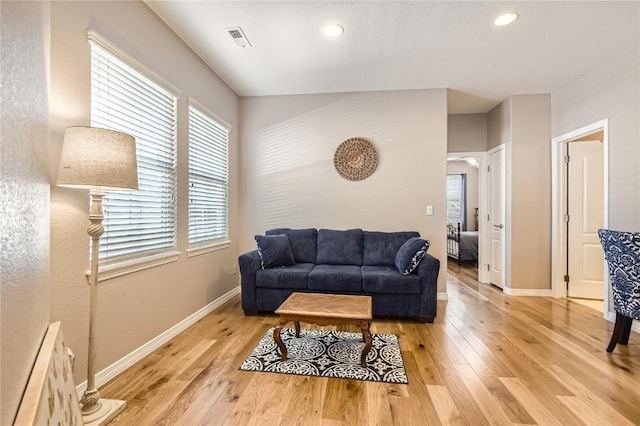 living area with light wood finished floors, baseboards, and recessed lighting