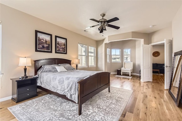 bedroom with baseboards, light wood finished floors, and a ceiling fan