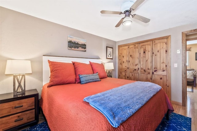 bedroom with baseboards, wood finished floors, and ceiling fan