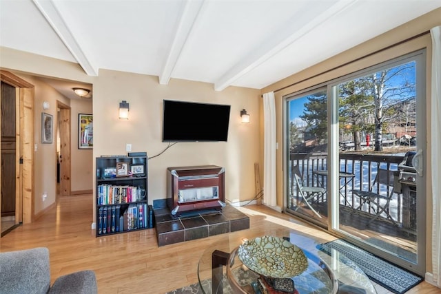 living room with baseboards, wood finished floors, and beamed ceiling