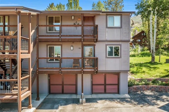 2930 Columbine Dr Unit 102, Steamboat Springs, CO 80487 - back of property featuring a balcony, an attached garage, driveway, and stairs