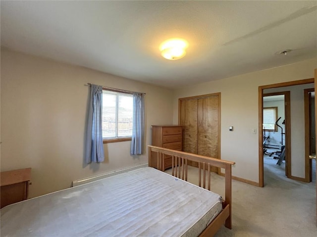 21725 4th Ave, Phippsburg, CO 80469 - bedroom featuring a closet, light carpet, and a baseboard heating unit