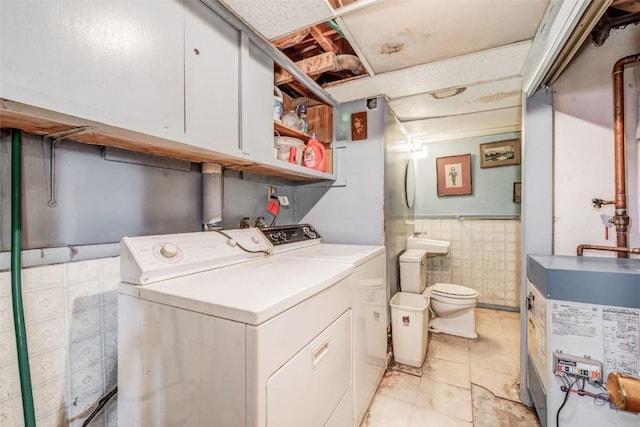 washroom featuring tile walls and washing machine and clothes dryer