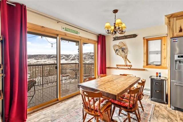 2626 Longthong Rd Unit 104, Steamboat Springs, CO 80487 - dining space with a chandelier, a mountain view, and baseboard heating