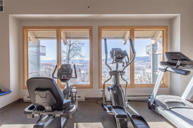 workout area featuring dark carpet, baseboards, a baseboard heating unit, and visible vents