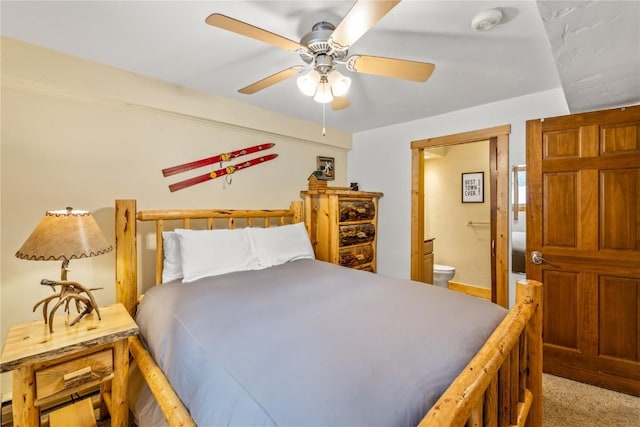 carpeted bedroom with a ceiling fan and ensuite bath