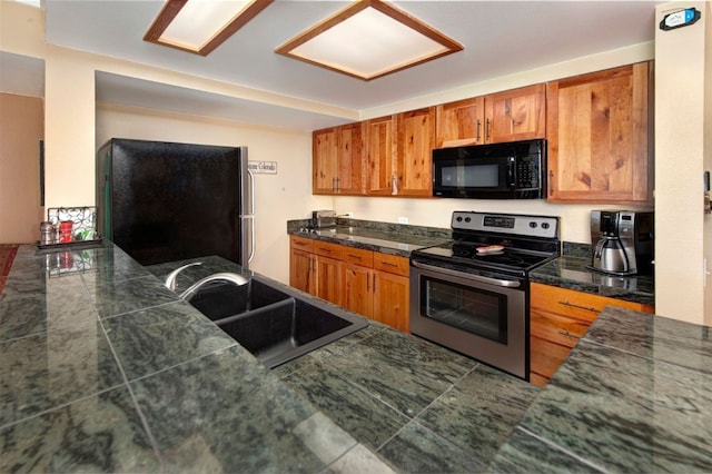 21640 US Highway 6 Unit 2122, Keystone, CO 80435 - kitchen with black microwave, stainless steel electric stove, freestanding refrigerator, brown cabinetry, and tile counters