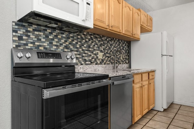 20 Sequoia Ct Unit 20, Steamboat Springs, CO 80487 - kitchen featuring stainless steel appliances, a sink, backsplash, light tile patterned flooring, and light stone countertops