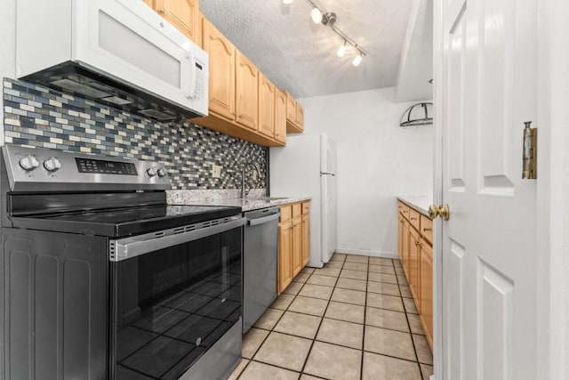 20 Sequoia Ct Unit 20, Steamboat Springs, CO 80487 - kitchen with stainless steel appliances, light brown cabinets, tasteful backsplash, light tile patterned flooring, and a textured ceiling