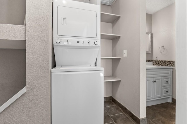 20 Sequoia Ct Unit 20, Steamboat Springs, CO 80487 - clothes washing area featuring estacked washer and dryer, baseboards, and a textured wall