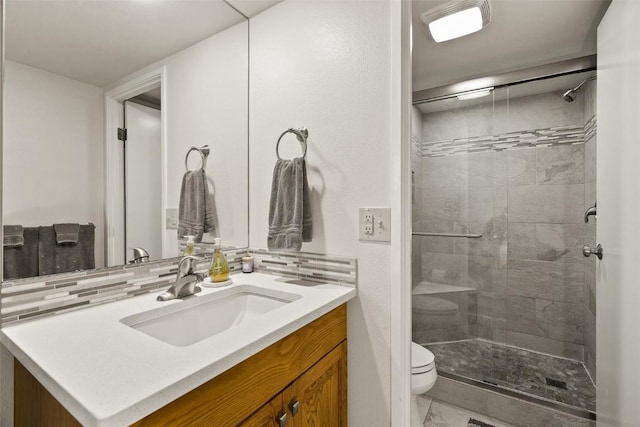 full bathroom featuring a stall shower, vanity, marble finish floor, backsplash, and toilet
