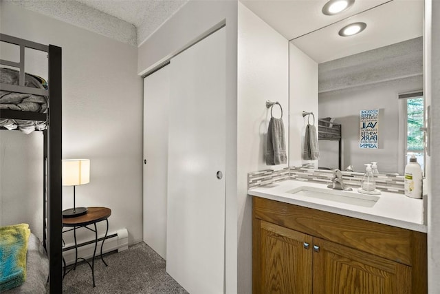 bathroom with a baseboard heating unit, tasteful backsplash, and vanity