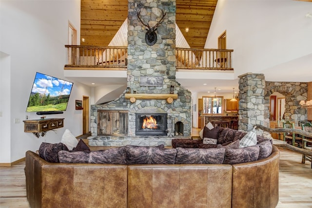 living room featuring a fireplace, wood finished floors, high vaulted ceiling, and wooden ceiling