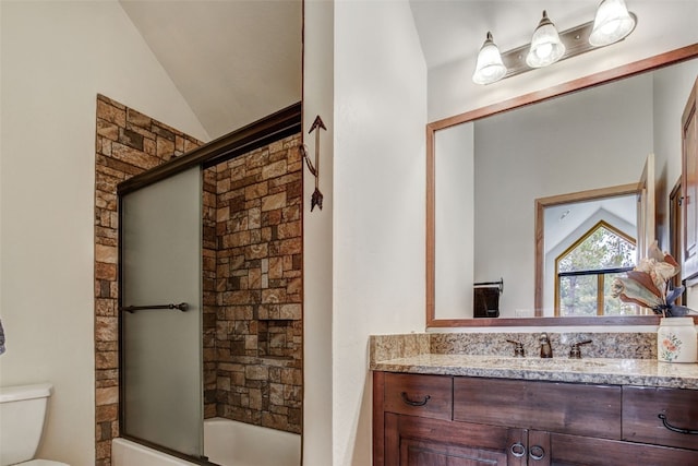 bathroom with bath / shower combo with glass door, vanity, toilet, and lofted ceiling