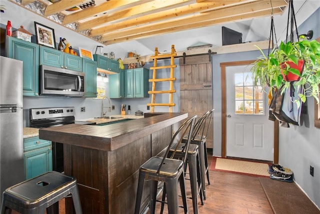 1295 Conestoga Cir, Steamboat Springs, CO 80487 - kitchen featuring appliances with stainless steel finishes, wooden counters, a sink, wood finished floors, and a breakfast bar