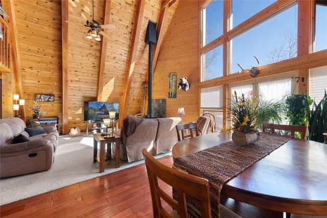 26635 Neptune Pl, Clark, CO 80428 - dining area with high vaulted ceiling, wood walls, wood-type flooring, beam ceiling, and ceiling fan