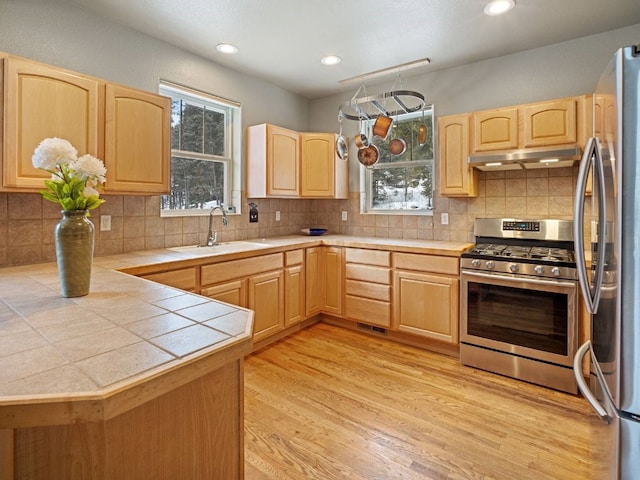 234 Peterson Dr, Alma, CO 80440 - kitchen with light brown cabinetry, stainless steel appliances, tile counters, under cabinet range hood, and recessed lighting