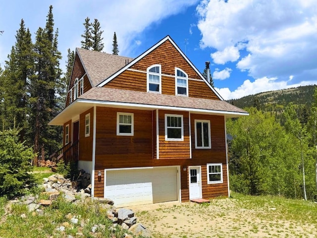 234 Peterson Dr, Alma, CO 80440 - view of front of house with a garage, roof with shingles, and a wooded view