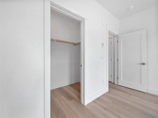 740 Blue River Pkwy Unit A21, Silverthorne, CO 80498 - unfurnished bedroom with a walk in closet, a closet, light wood finished floors, and baseboards