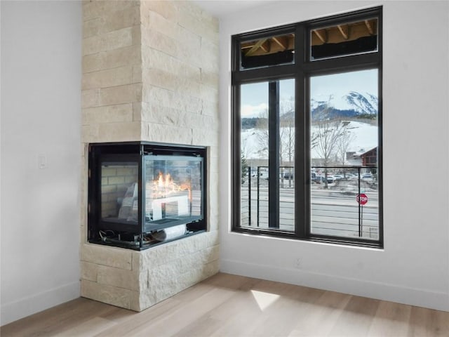 740 Blue River Pkwy Unit A21, Silverthorne, CO 80498 - interior space with baseboards, wood finished floors, and a multi sided fireplace