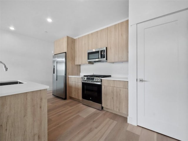 740 Blue River Pkwy Unit A21, Silverthorne, CO 80498 - kitchen featuring a sink, light brown cabinetry, light wood-style floors, light countertops, and appliances with stainless steel finishes