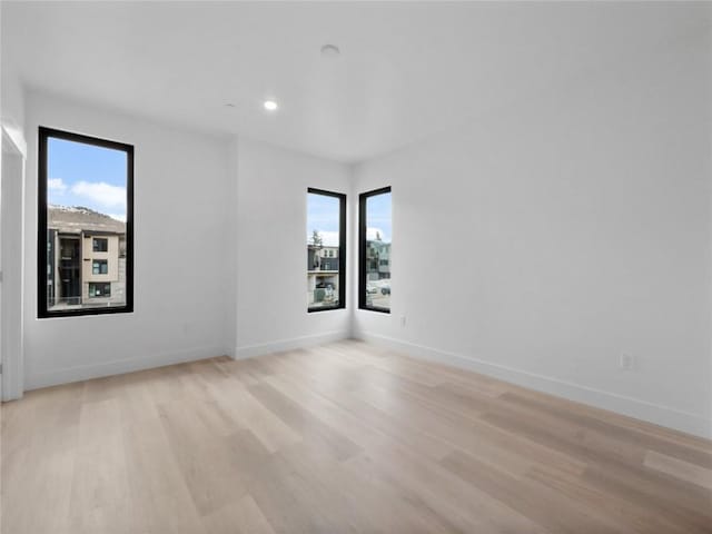 740 Blue River Pkwy Unit A21, Silverthorne, CO 80498 - unfurnished room with plenty of natural light, baseboards, and light wood-style floors