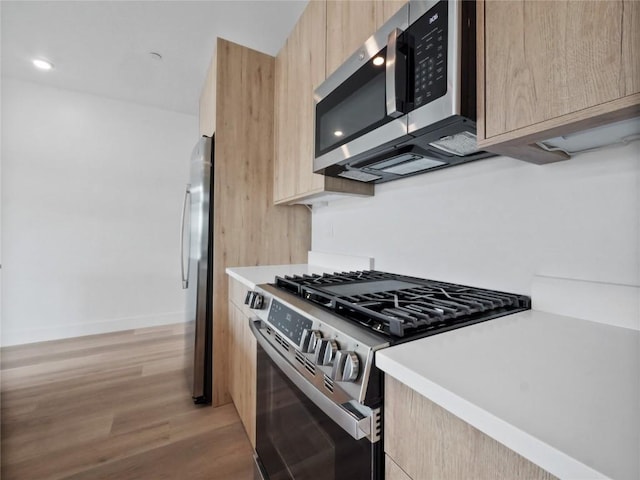 740 Blue River Pkwy Unit A21, Silverthorne, CO 80498 - kitchen featuring light wood finished floors, light brown cabinetry, appliances with stainless steel finishes, and modern cabinets