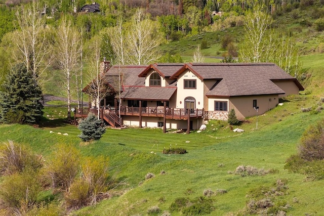 31695 Aspen Ridge Rd, Steamboat Springs, CO 80487 - back of property with a chimney, a deck, stucco siding, and a lawn