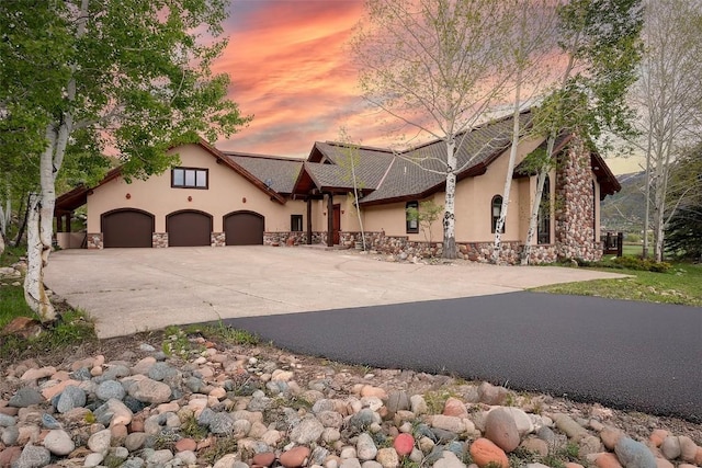 31695 Aspen Ridge Rd, Steamboat Springs, CO 80487 - view of front of house with stucco siding, driveway, stone siding, and a garage