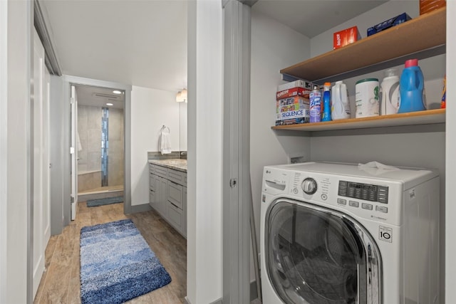 laundry area featuring washer / clothes dryer, light wood-style floors, and laundry area