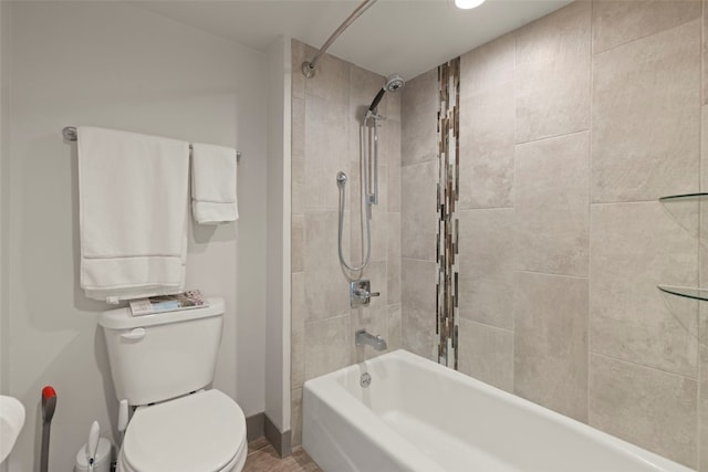 bathroom featuring baseboards, tub / shower combination, and toilet
