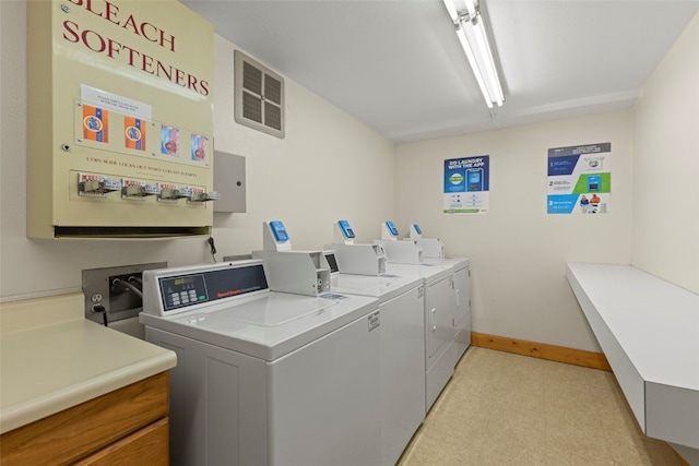 community laundry room with washer and dryer, baseboards, and visible vents