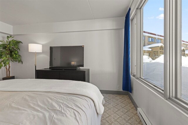 bedroom featuring a baseboard heating unit and baseboards