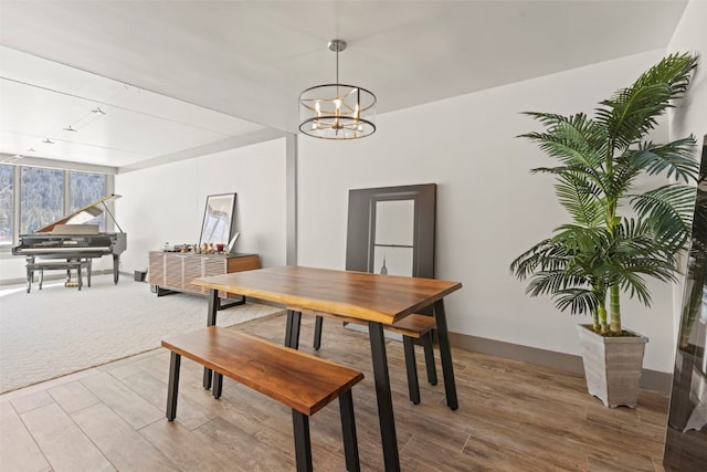 dining area featuring a chandelier, track lighting, and wood finished floors
