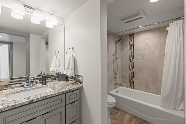 full bathroom featuring shower / bath combo, toilet, visible vents, wood finished floors, and vanity