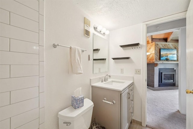 4200 Lodge Pole Cir Unit 205, Silverthorne, CO 80498 - half bathroom featuring vanity, a glass covered fireplace, and a textured ceiling