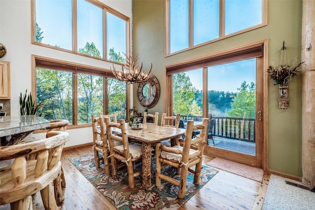 1996 Al Gulch Rd, Jefferson, CO 80456 - dining area featuring a high ceiling, light wood finished floors, and a chandelier