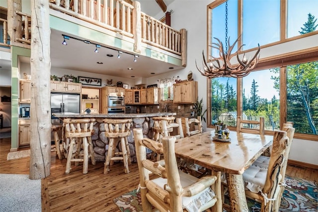 1996 Al Gulch Rd, Jefferson, CO 80456 - dining space featuring a chandelier, light wood-type flooring, and a towering ceiling