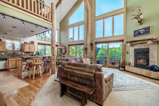 1996 Al Gulch Rd, Jefferson, CO 80456 - living area with a towering ceiling, a fireplace, light wood-type flooring, and a chandelier