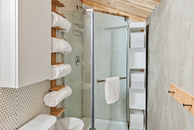 932 Peterson Dr, Alma, CO 80420 - full bathroom with toilet, a shower stall, vaulted ceiling, and tasteful backsplash