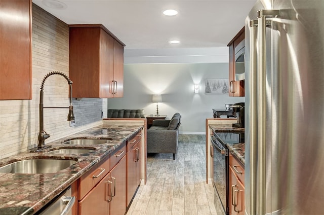 9359 State Highway 9 Unit G5, Breckenridge, CO 80424 - kitchen featuring stainless steel appliances, a sink, baseboards, light wood-type flooring, and dark stone counters