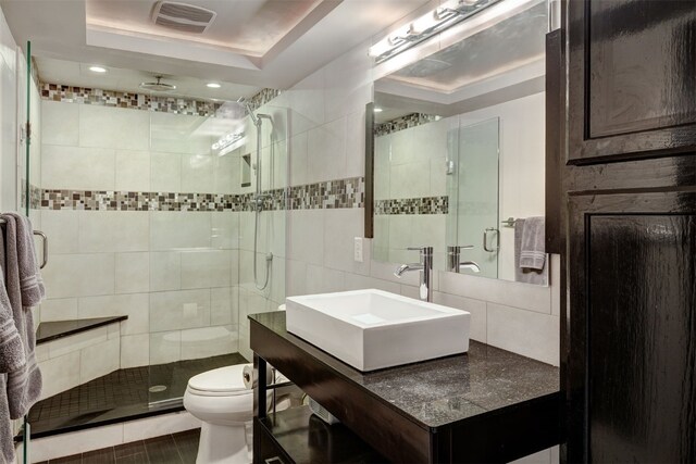 9359 State Highway 9 Unit G5, Breckenridge, CO 80424 - full bathroom with vanity, toilet, a shower stall, decorative backsplash, and tile walls
