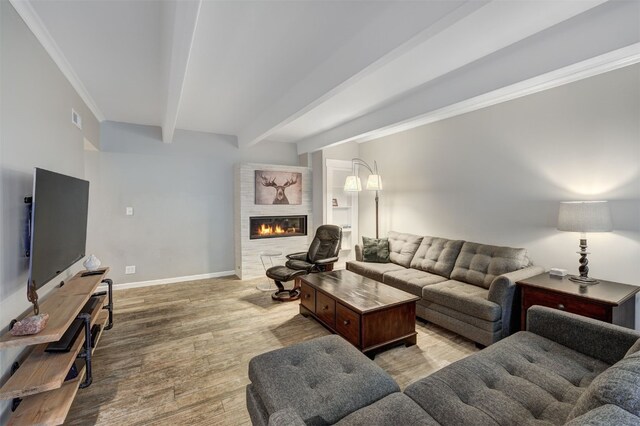 9359 State Highway 9 Unit G5, Breckenridge, CO 80424 - living area with beam ceiling, a glass covered fireplace, light wood-type flooring, baseboards, and crown molding