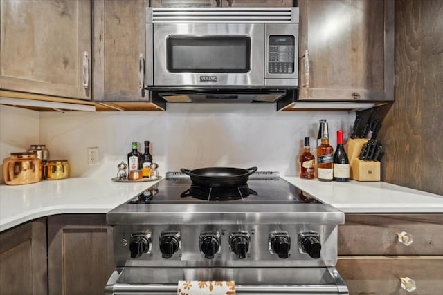 910 Copper Rd Unit 105, Frisco, CO 80443 - kitchen with stainless steel microwave, range, tasteful backsplash, and light countertops