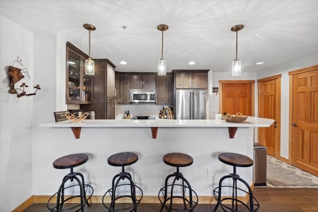 910 Copper Rd Unit 105, Frisco, CO 80443 - kitchen with appliances with stainless steel finishes, light countertops, glass insert cabinets, a peninsula, and a breakfast bar area