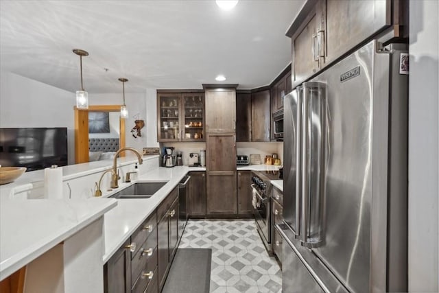 910 Copper Rd Unit 105, Frisco, CO 80443 - kitchen with appliances with stainless steel finishes, a sink, dark brown cabinets, light countertops, and pendant lighting