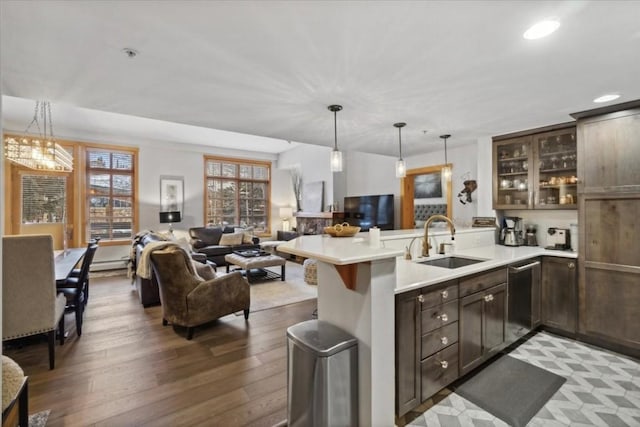 910 Copper Rd Unit 105, Frisco, CO 80443 - kitchen with a sink, stainless steel dishwasher, open floor plan, a peninsula, and dark brown cabinetry