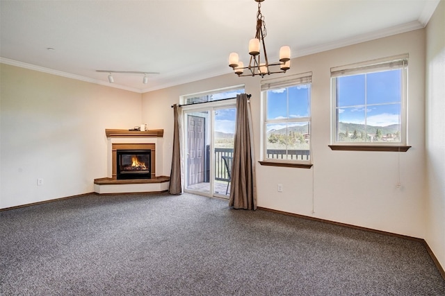 951 N Ten Mile Dr Unit C15, Frisco, CO 80443 - unfurnished living room featuring carpet floors, a chandelier, track lighting, a glass covered fireplace, and crown molding