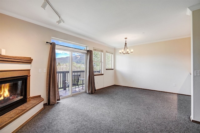 951 N Ten Mile Dr Unit C15, Frisco, CO 80443 - unfurnished living room with crown molding, carpet flooring, a chandelier, a glass covered fireplace, and rail lighting