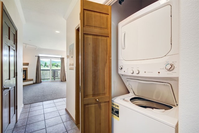 951 N Ten Mile Dr Unit C15, Frisco, CO 80443 - laundry room with estacked washer and dryer, light colored carpet, a warm lit fireplace, recessed lighting, and light tile patterned floors